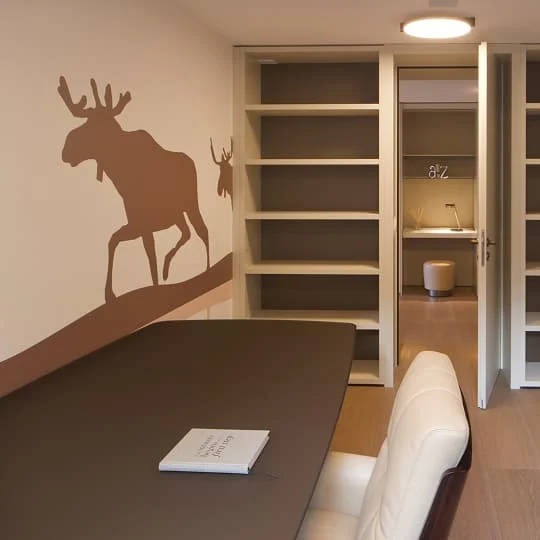 arbeitszimmer mit regalen und elchmotiv