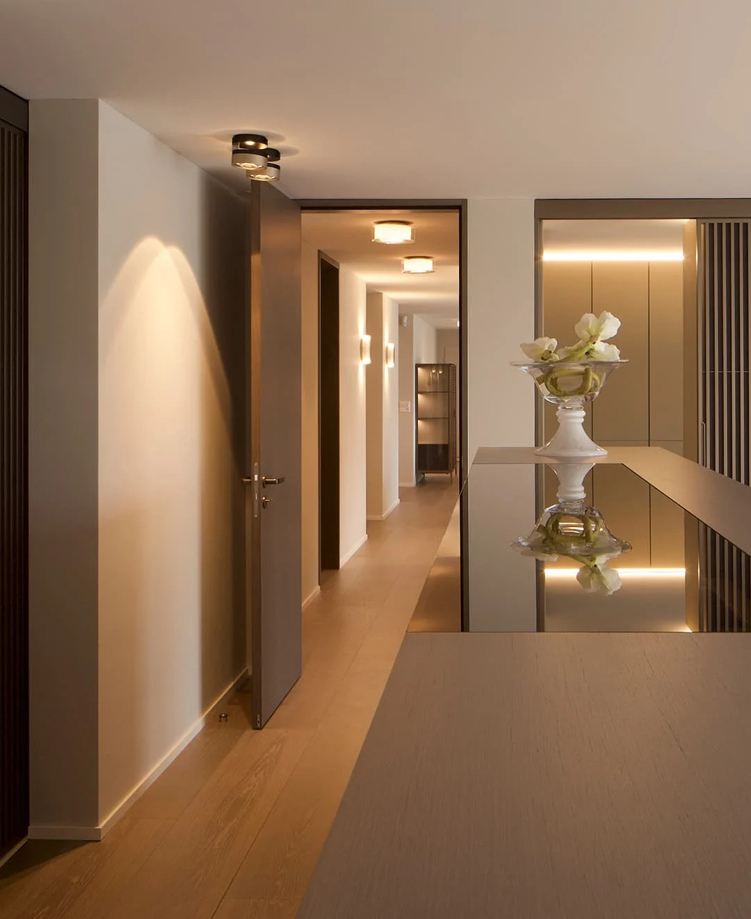 Eleganter Flur mit warmem Licht, modernen Einbauschränken und Holzdetails – stilvolles Interior-Design mit klaren Linien und ruhiger Atmosphäre.