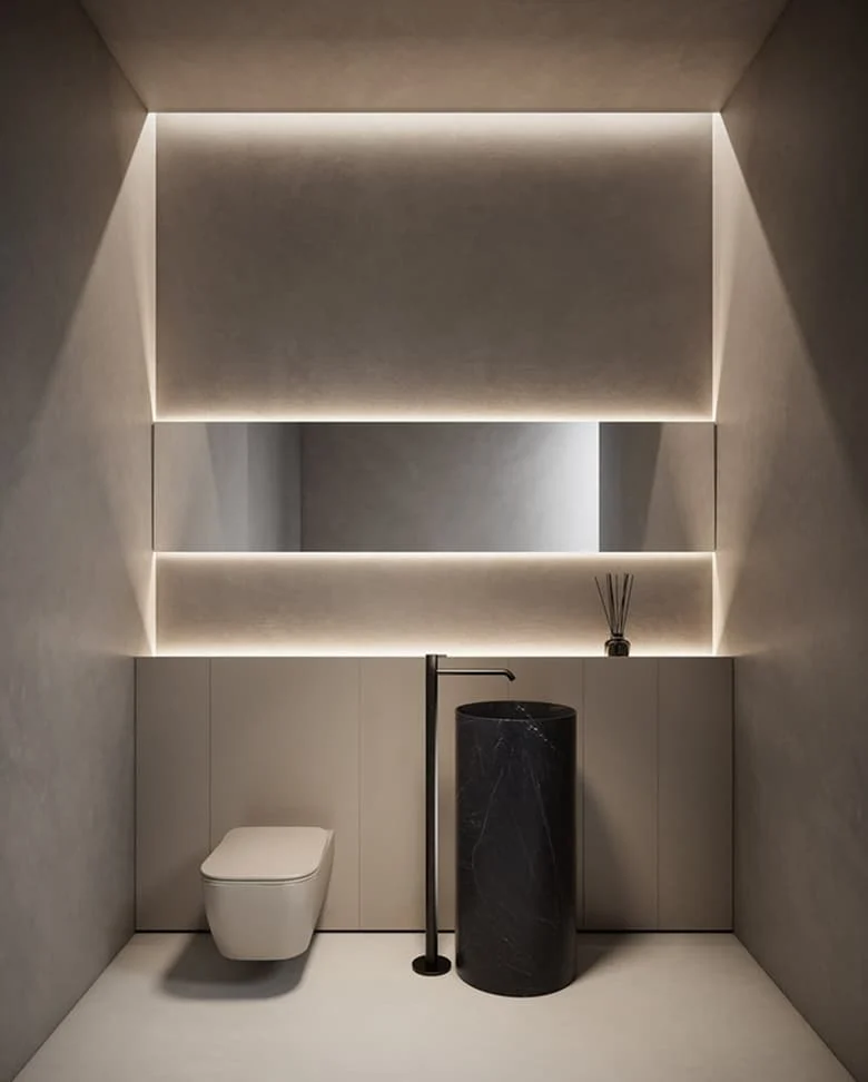 Minimalistisches Gäste WC mit indirekter Beleuchtung, wandhängender Toilette und freistehendem schwarzem Marmorwaschbecken.
