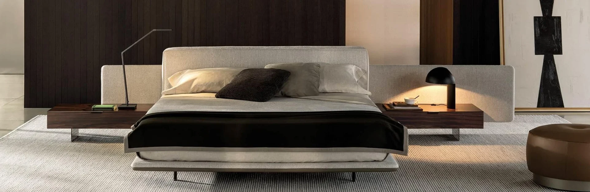 Modernes Schlafzimmer mit einem breiten Polsterbett, seitlichen Holznachtkonsolen, minimalistischen Lampen und warmen Naturtönen.
