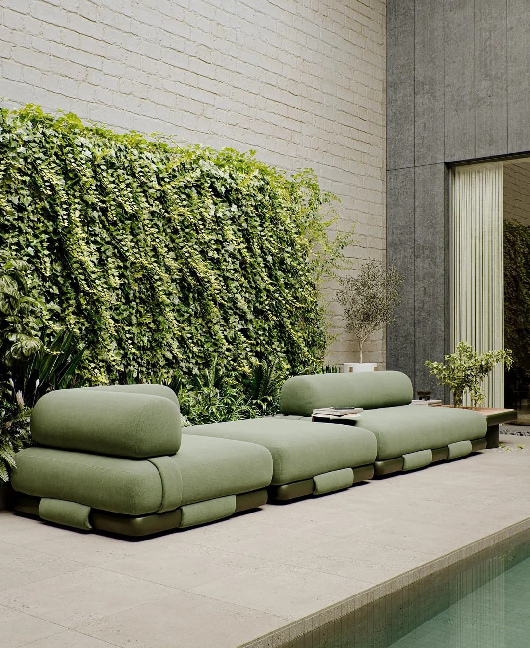 Grüne Outdoor-Lounge mit modularen Polstermöbeln vor üppiger Pflanzenwand am Pool.