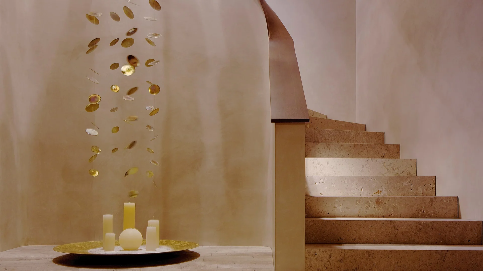 Elegante Steintreppe mit abgerundeter Wand und goldener Deko-Installation mit Kerzen im modernen Eingangsbereich.