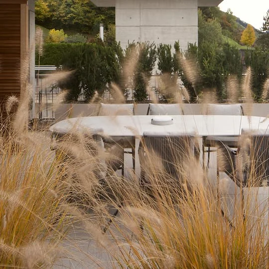 terrasse mit aussicht und esstisch hinter gras