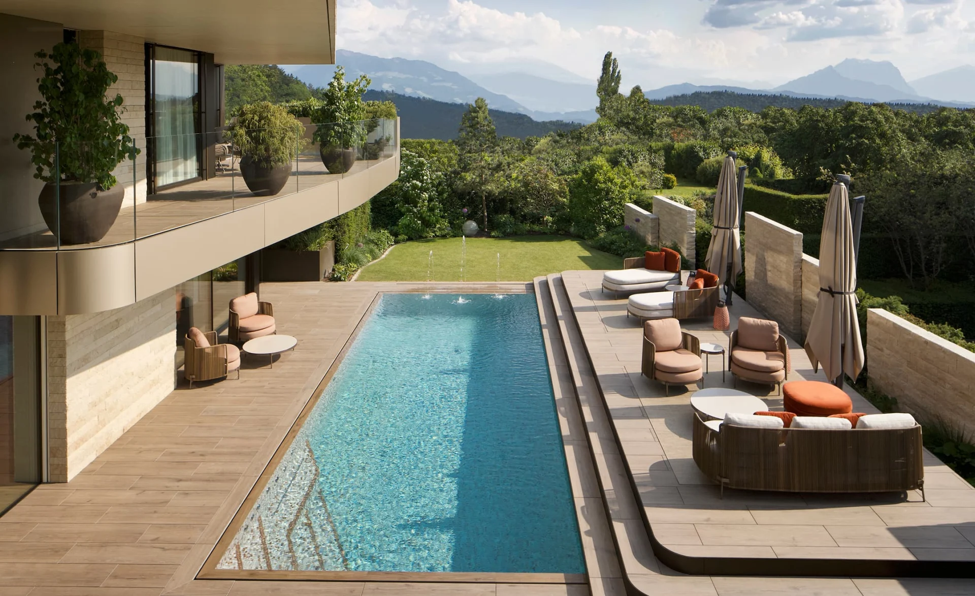 Luxuriöse Terrasse mit Pool, modernen Lounge-Möbeln und Panoramablick auf Berge und Natur.