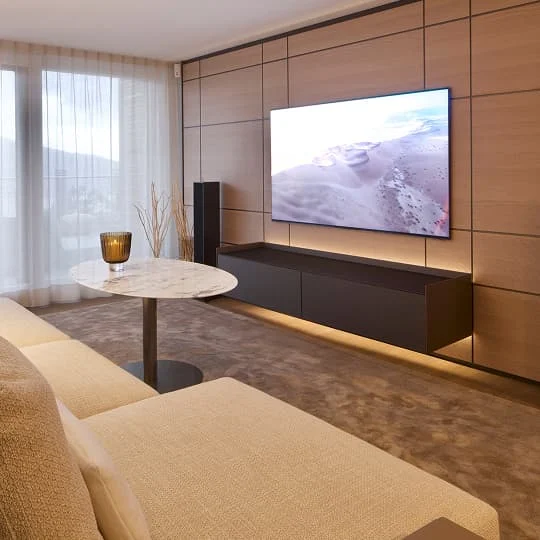 wohnzimmer mit holzpaneelen und wandtv